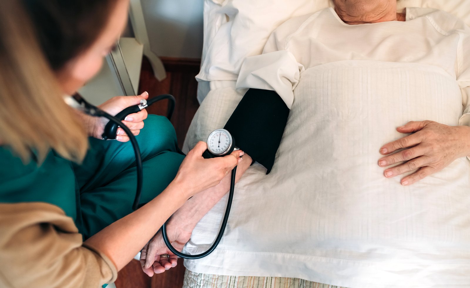 Caregiver checking blood pressure to a senior woman