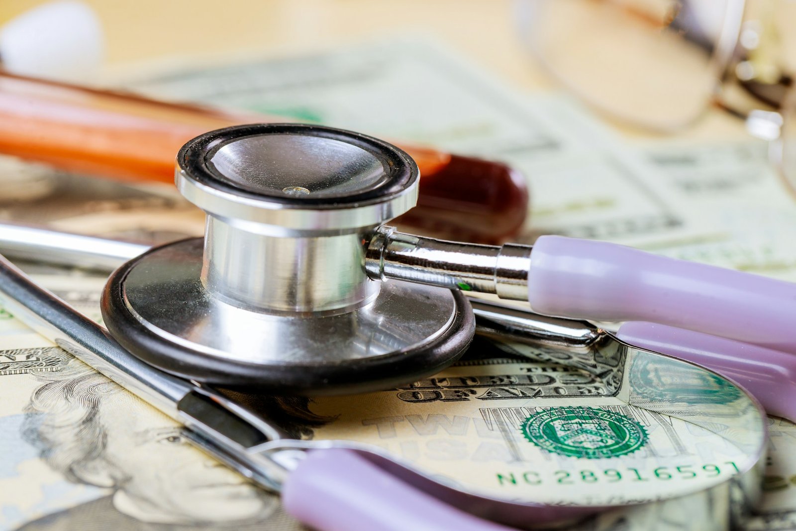 Healthcare and medicine health insurance, stethoscope on the money, blood test tubes